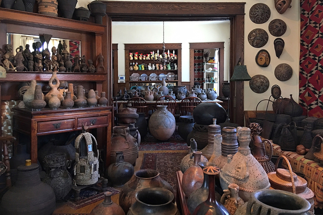 Hundreds of ethnographic objects—filling nearly every wall and flat surface—are displayed in a home.