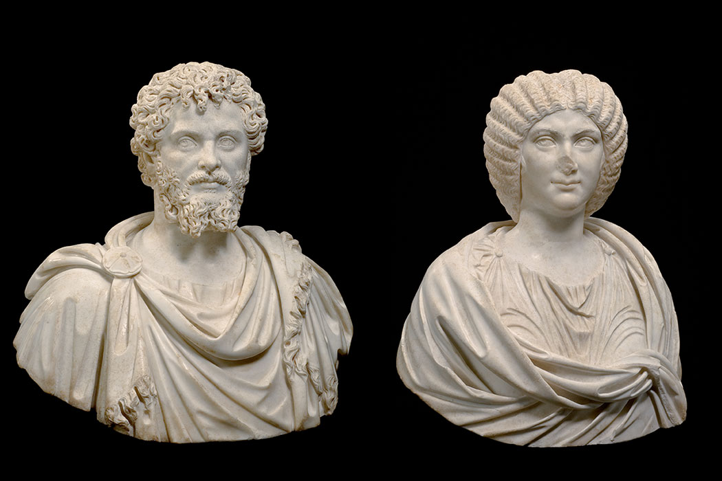 Two marble busts, one of a man, one of a woman.